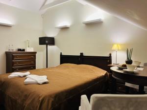 a bedroom with a bed and a dresser and a table at Monte Pacis in Kaunas
