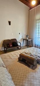 a bedroom with a bed with a couch and a table at Casa Especial em Catas Altas in Catas Altas