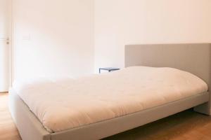 ein weißes Bett in einem Zimmer mit einer weißen Wand in der Unterkunft Quiet apartment near the Flea Market in Saint-Ouen