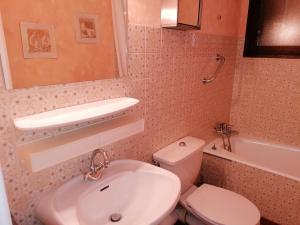 uma casa de banho com um lavatório, um WC e um espelho. em Studio Le Grand-Bornand, 1 pièce, 4 personnes - FR-1-241-227 em Le Grand-Bornand