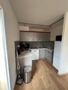 Elle comprend une petite cuisine avec des placards blancs et un évier. dans l'établissement Appartement unique dans le domaine de la sangliere, à Bormes-les-Mimosas