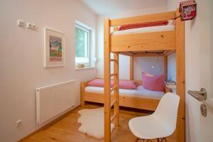 a small room with a bunk bed and a chair at Chalet am Breitenberg in Pfronten