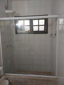 ein Bad mit einer Dusche, einem Fenster und einem WC in der Unterkunft Quarto Oceânico - Praia de Piratininga in Niterói