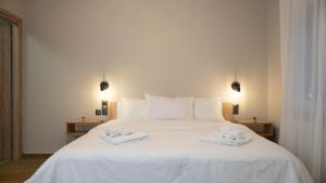 a white bed with two towels on top of it at "LaGo Village House" Family & Group Retreat near Meteora in Kalabaka