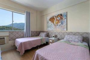una camera con due letti e una foto di una tigre di MARCOLINI - Cidade Olímpica - Quality Green a Rio de Janeiro