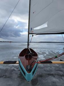 a small sail boat sitting on a body of water at Dom z sauną i widokiem na jezioro in Pluski