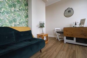 uma sala de estar com um sofá verde e uma cómoda em Lovely flat in Notting Hill- 1 min to the tube em Londres