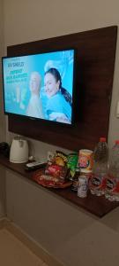 uma televisão de ecrã plano numa prateleira com comida em Glamour Hotel and Spa em Medan