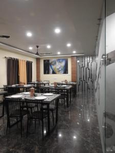 un restaurante con mesas y sillas y una pintura en la pared en hp greenland resort, en Lataguri