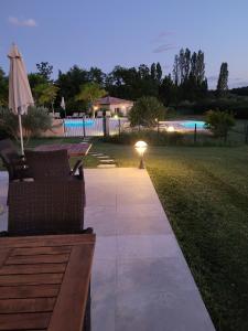 eine Terrasse mit 2 Stühlen und einem Tisch mit Licht in der Unterkunft Hôtel La Bastide d'Iris in Vagnas