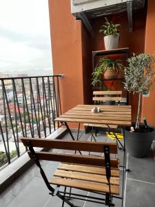 ティラナにあるBliss Apartmentの木製ベンチとテーブル付きのバルコニー