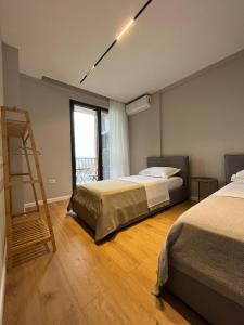ティラナにあるBliss Apartmentのベッドルーム1室(ベッド2台、はしご付)