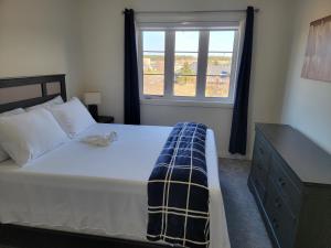 ein Schlafzimmer mit einem großen Bett und einem Fenster in der Unterkunft Chorburjo Cozy Villa - Two Rooms in Penetanguishene