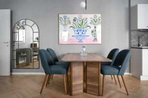 uma sala de jantar com uma mesa e cadeiras azuis em numa I Terra Apartments em Viena