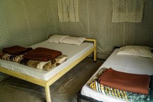 a couple of beds in a room at The FnF Resort & Camping - Rishikehs in Rishīkesh