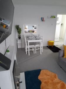 ein Wohnzimmer mit einem Tisch und einem Esszimmer in der Unterkunft Cosy Apartment with Balcony and Breakfast in Bishop Auckland