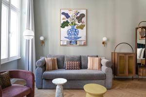 ein Wohnzimmer mit einem Sofa und einer Vase aus Blumen in der Unterkunft Numa Vienna Terra in Wien
