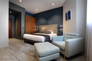 エクスレバンにあるHotel des Eauxのベッドと椅子付きのホテルルーム