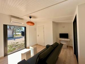 ein Wohnzimmer mit einem Sofa und einem TV in der Unterkunft Camping Golfo Di Sogno in Porto-Vecchio