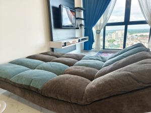 a large couch in a room with a large window at #Free Netflix 1BR Troika Residensi Kota Bharu By AGhome in Kota Bharu