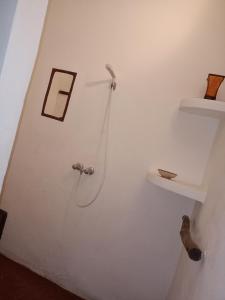 La salle de bains blanche est pourvue d'une douche et d'une étagère. dans l'établissement Riad Sahara Sunset Beach Agadir, à Douaïra
