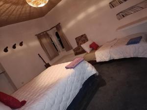 a bedroom with two beds and a chandelier at Riad Sahara Sunset Beach Agadir in Douaïra