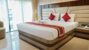 a bedroom with a large bed with red pillows at Hotel Daltin in Digha