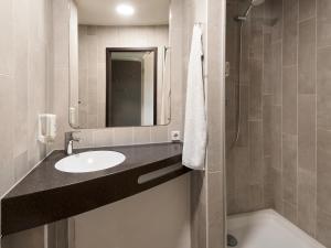a bathroom with a sink and a shower at B&B Hotel Offenbach-Süd in Offenbach