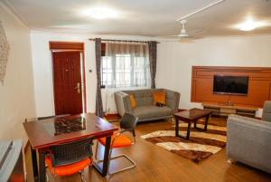 a living room with a couch and a table at R & R FURNISHED APPARTMENT AKRIGHT CITY BWEBAJJA in Bwebajja
