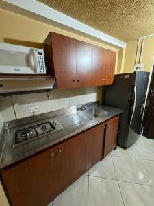 a kitchen with a sink and a microwave at Apartaestudio en Medellín in Medellín