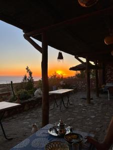 a table with food on it with the sunset in the background at SurfcampLagrotte in Essaouira