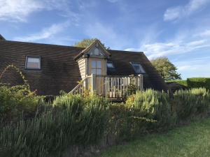 a house with a wooden porch and a fence at The Loft in South Stoke