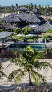 ein Resort am Strand mit einer Palme in der Unterkunft LaVentana Tatajuba in Tatajuba