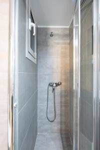 a shower with a glass door in a bathroom at Newly Renovated Cozy Studio Downtown Athens in Athens