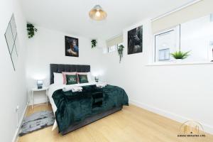 Persephone Apartment - The Goddess of Town في ساوثهامبتون: غرفة نوم بيضاء مع سرير وبطانية خضراء