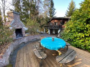 a patio with a table and chairs and a fireplace at Chalet De Ravers in Durbuy