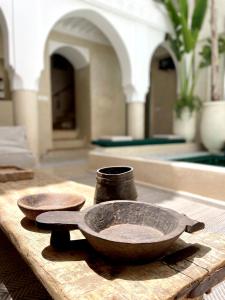 two bowls are sitting on a wooden table at RIAD ILYM - Riad privatif Marrakech Medina in Marrakesh