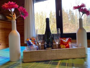 drewniana taca z butelkami i kieliszkami na stole w obiekcie Chalet De Ravers w mieście Durbuy