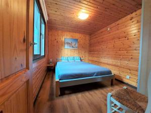 een slaapkamer met een bed in een houten hut bij Chalet De Ravers in Durbuy