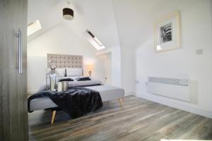 a white bedroom with a bed and a table at Roundhay Flat Duplex - Sleeps 2 in Roundhay
