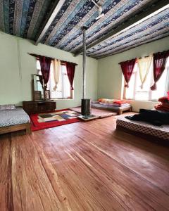 a room with two beds and a wooden floor at SpitiDiaries Homestay in Kaza