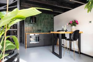 eine Küche mit einem Holztisch und schwarzen Stühlen in der Unterkunft Résidence Beaufort in Zandvoort