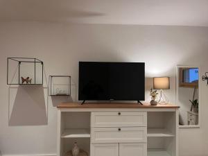 a flat screen tv sitting on top of a entertainment center at Ferienwohnung Agena in Schliersee