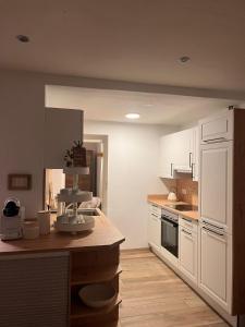 a kitchen with white cabinets and a counter top at Ferienwohnung Agena in Schliersee