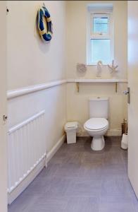 a bathroom with a toilet and a window at K Suites - Park Street in Grimsby