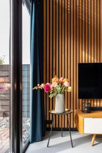 a vase of flowers sitting on a table in a room at Résidence Beaufort in Zandvoort +44 photos