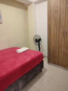 een slaapkamer met een bed met een rode deken bij GURUS FR | Apartamento cerca al Aeropuerto y Terminal 2 Hab in Pereira
