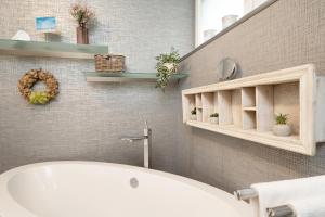 a bathroom with a white tub and a sink at Instenweg 14 Fischhus in Rettin