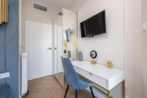 una scrivania bianca e una sedia blu in una stanza di 2-Bedroom DeLux Apartment with Private Sauna WWA25 a Varsavia
