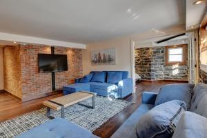 a living room with blue couches and a brick wall at Sublime Residence Downtown Montreal in Montréal